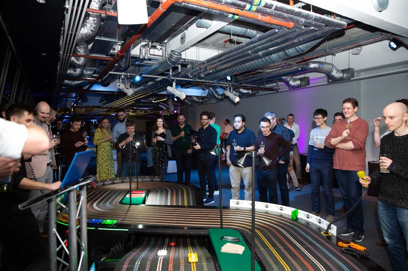 Extra large scalextric being playing by Quadrature team whilst drinking champagne