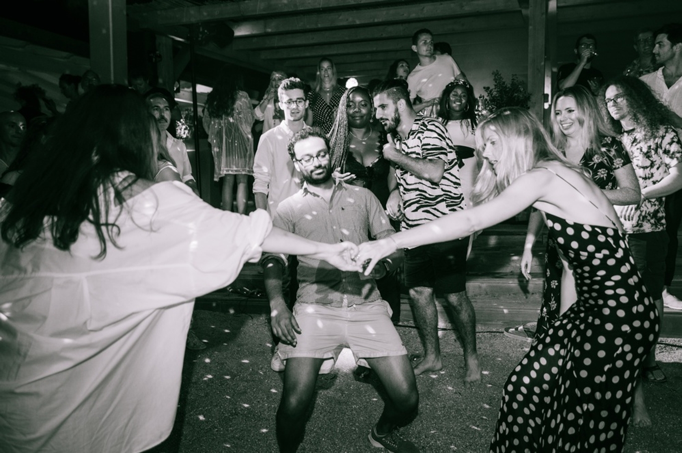 Black and white photo of people playing limbo at a party